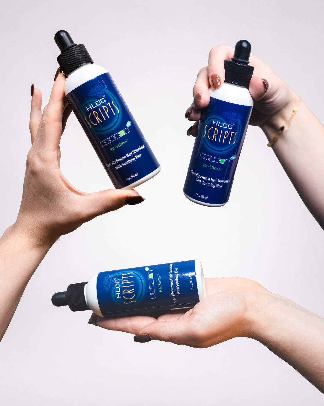 Three hands holding HLCC Scripts Re-Stim+ dropper bottles